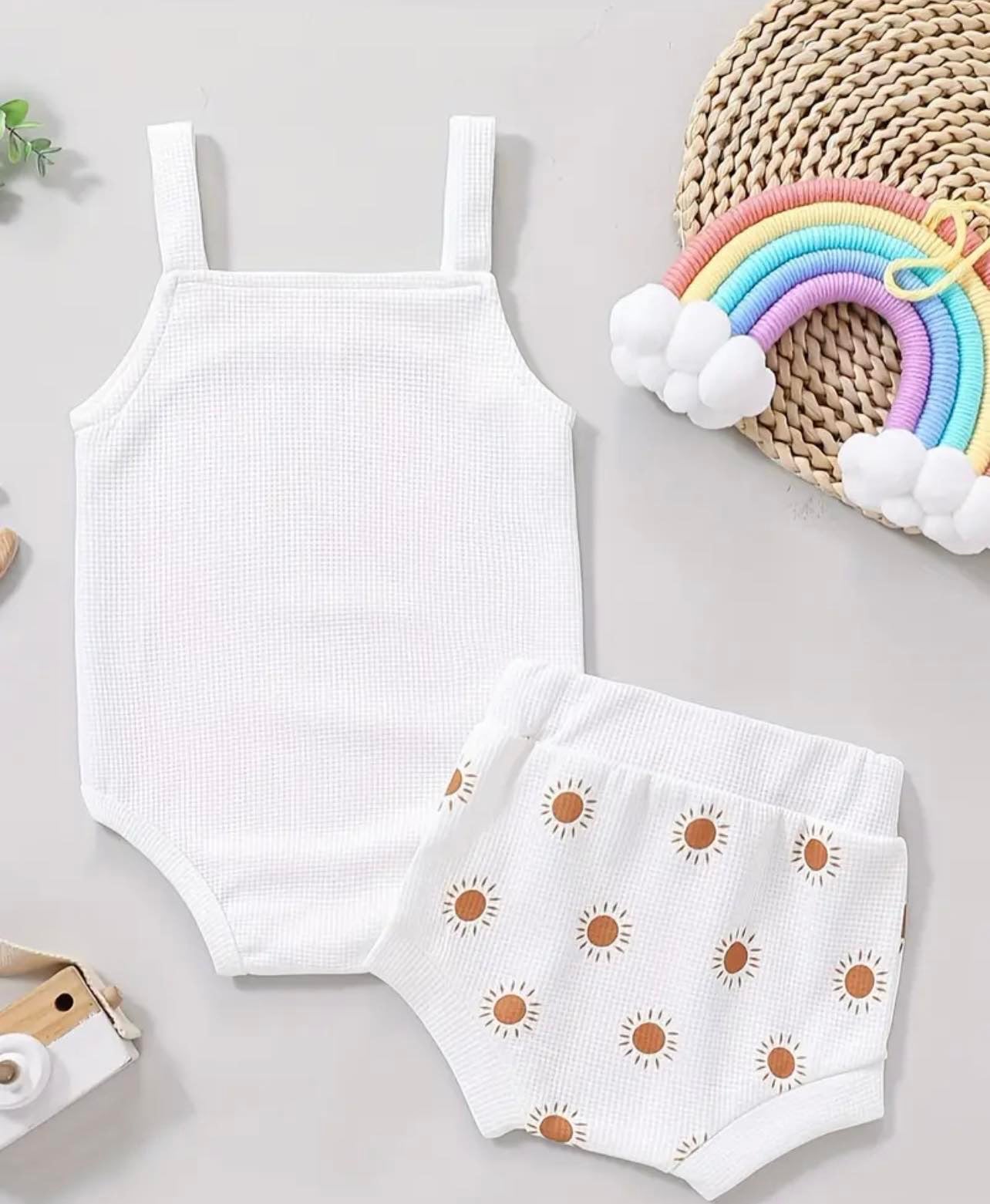 Adorable 2-piece baby girls' set with a cheerful sun graphic onesie and coordinating shorts for summer fun.