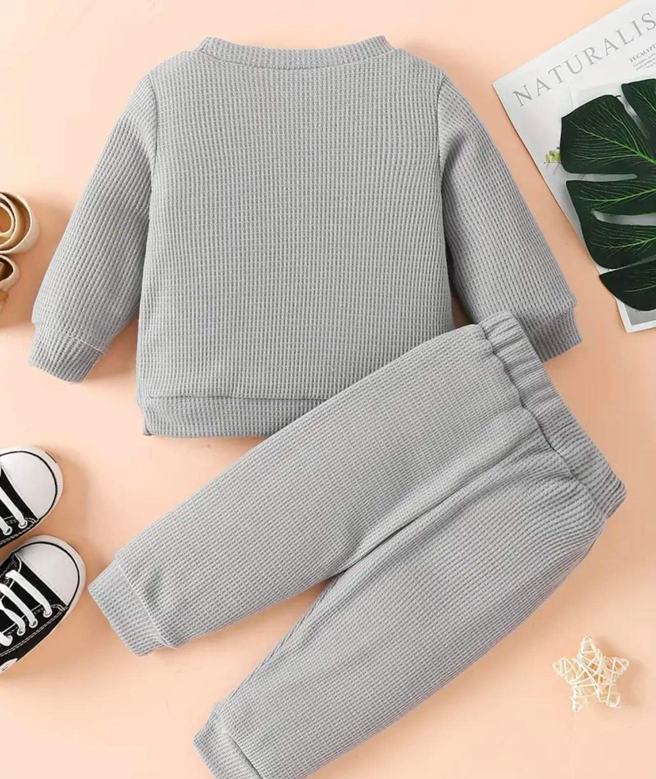 Toddler wearing a grey 2-piece sweater and pant set, perfect for cooler weather.