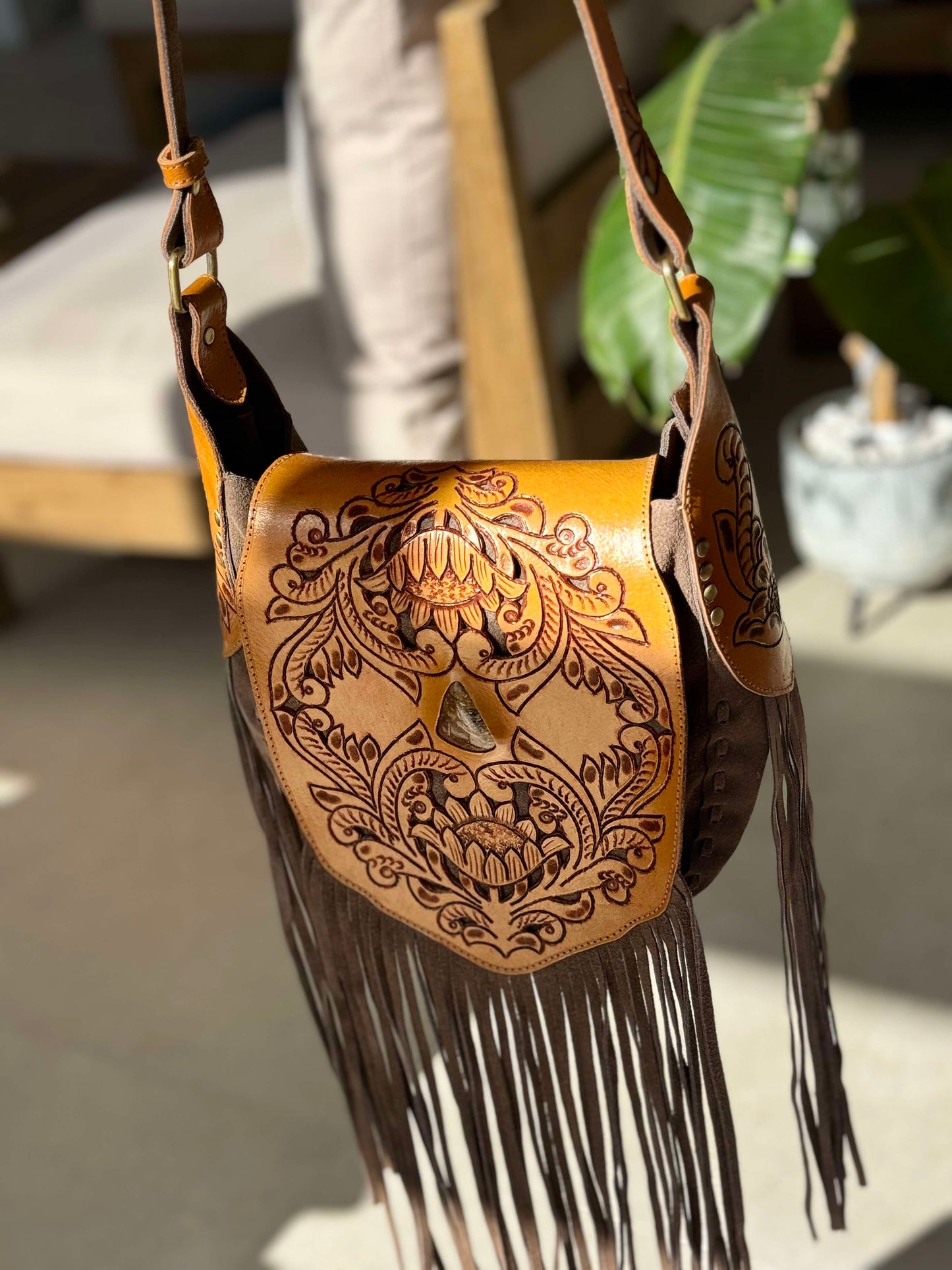 Boho-chic Montana crossbody bag with rich leather, fringe accents, and a secure magnetic closure beneath a buckle.