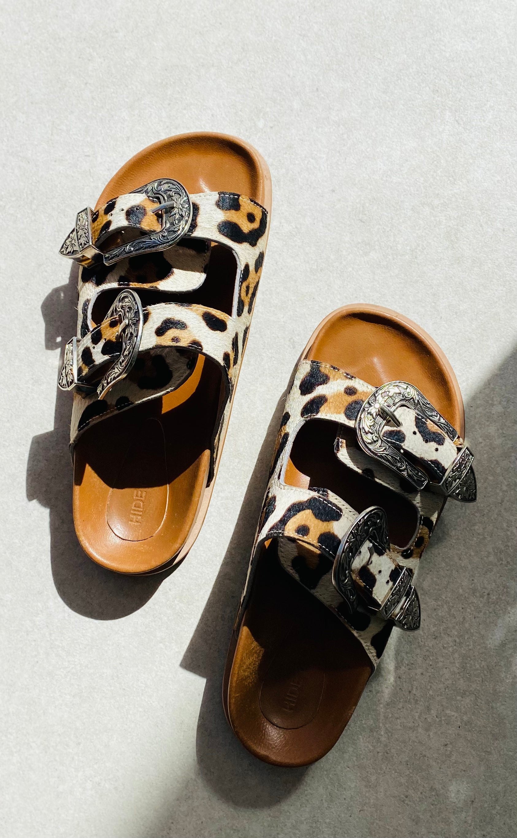 Western Slide Sandals with cowboy-style buckles and silver studs, featuring an open toe and adjustable straps, perfect for adding a touch of western flair to your outfit.