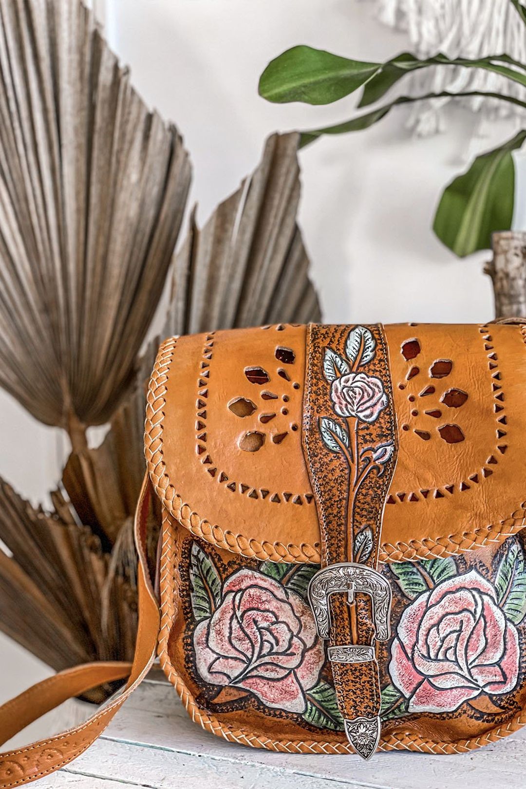 Daisy Mae Hand Painted Bag worn cross-body, showcasing its boho and Western-inspired design with an adjustable strap and silver hardware.