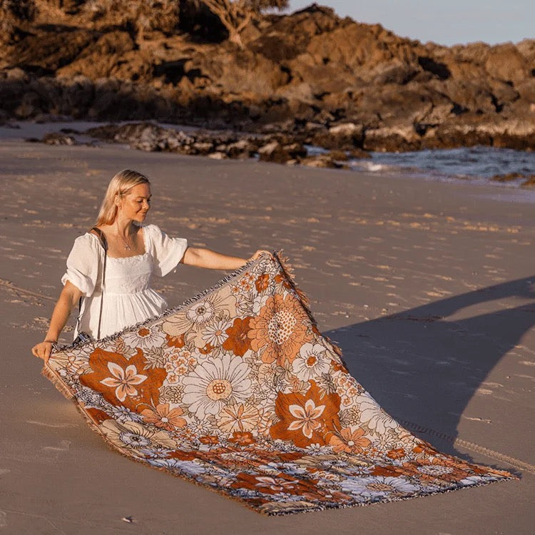 Lady on a beach with boho picnic rug bohemian, floral, folk design