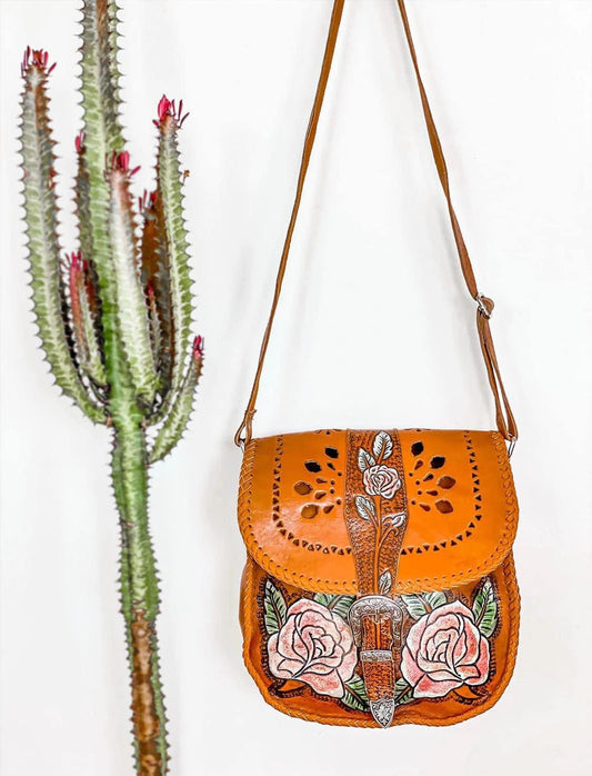 Hand-painted leather Daisy Mae Bag with rose design, featuring a press studded buckle closure and adjustable strap. Styled with Western silver hardware.