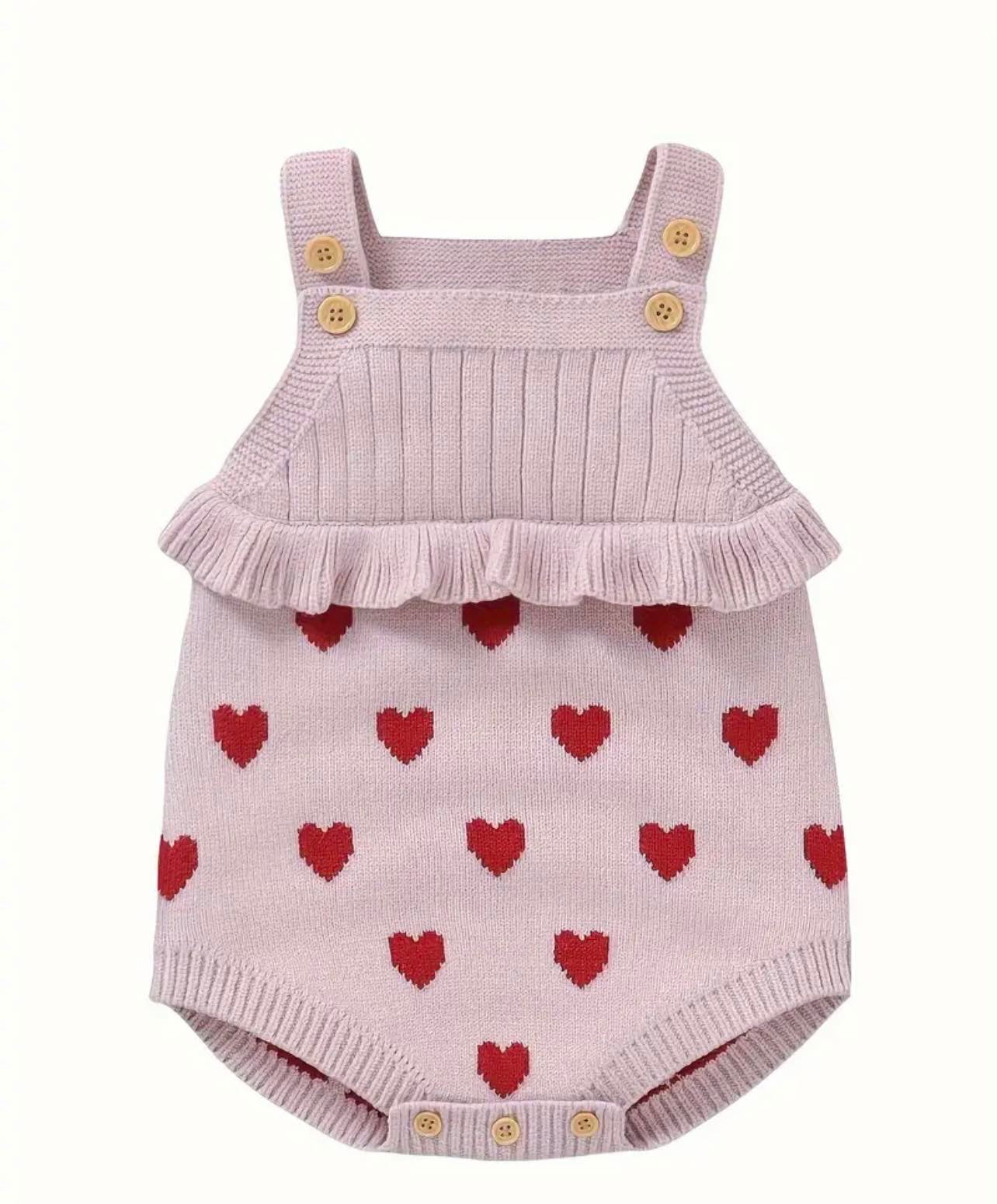 Baby wearing the Hearts Jacquard Ruffle Knit Onesie, featuring a heart print and ruffled square neck.