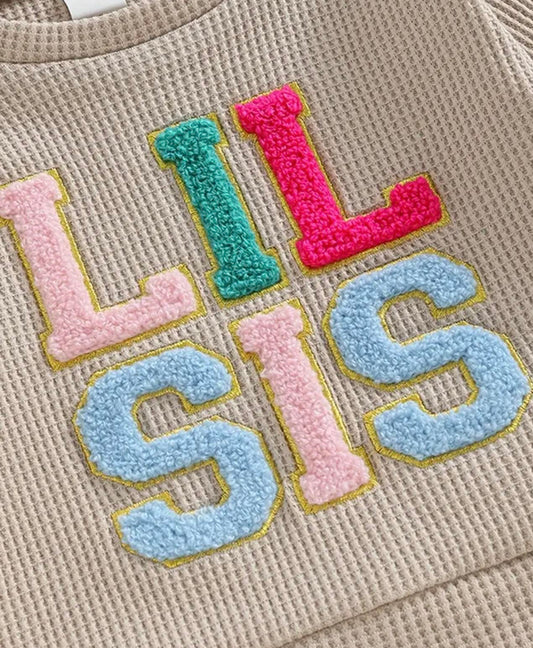 Lil Sis' Two Piece Tracksuit for baby and toddler girls, featuring colorful embroidered lettering and cozy waffle knit joggers