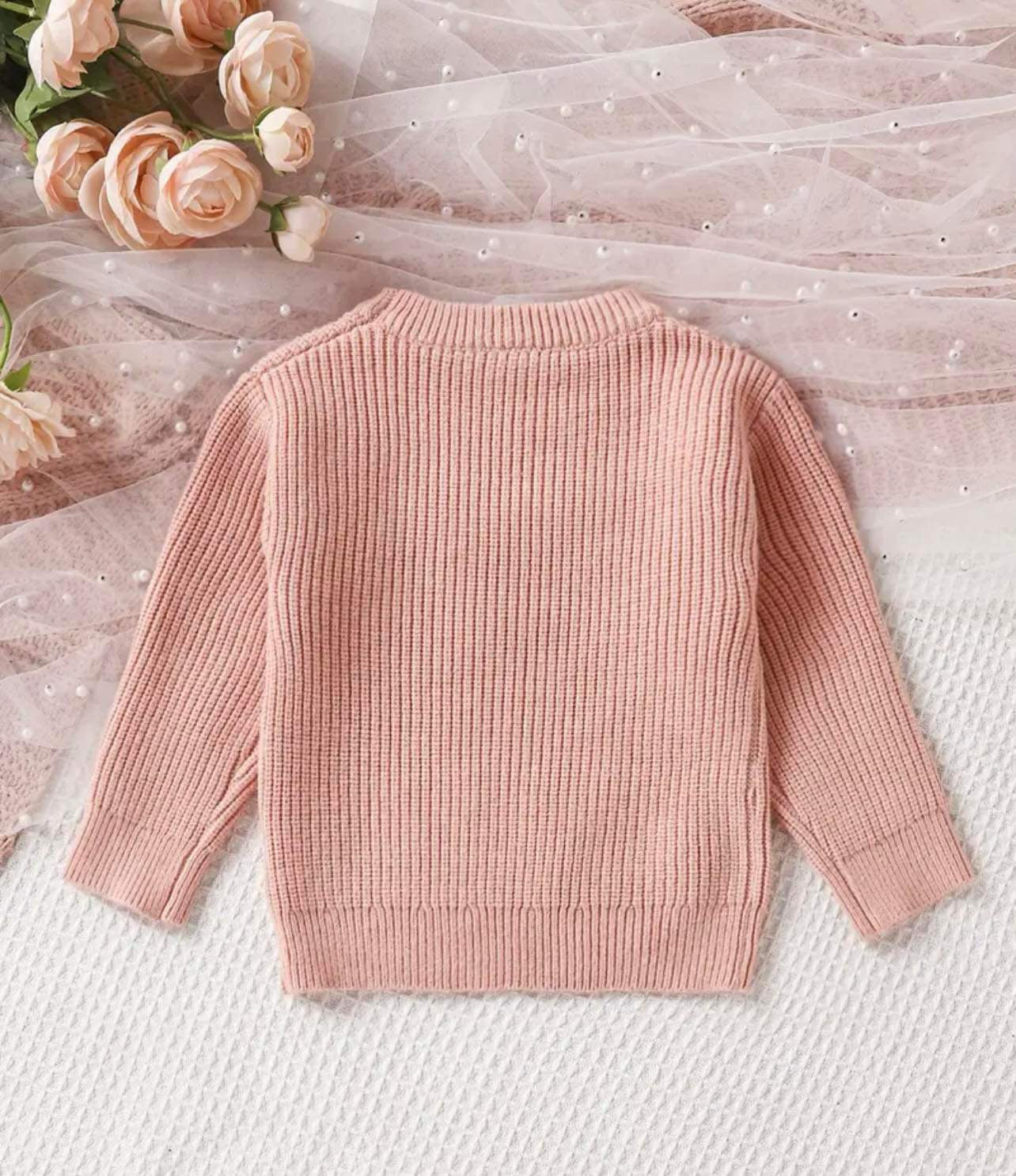 Back of the Little Love Knot Knit Sweater showcasing the letter embroidery detail on the soft, chunky knit fabric. The sweater is perfect for baby girls and boys, ideal for fall and winter wear.