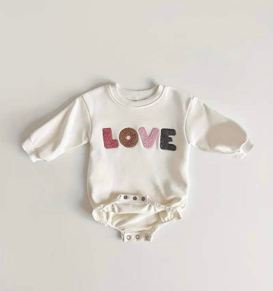 Pink Love romper for babies with embroidered slogan.