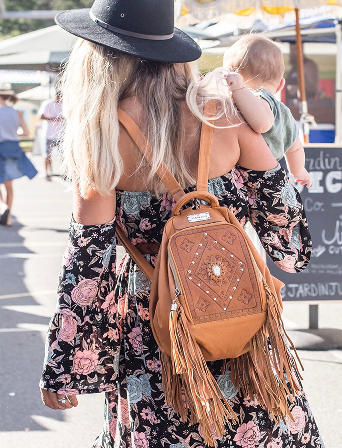 Close-up of the Seychelles leather purse backpack with hand tooling and soft fringe detailing.