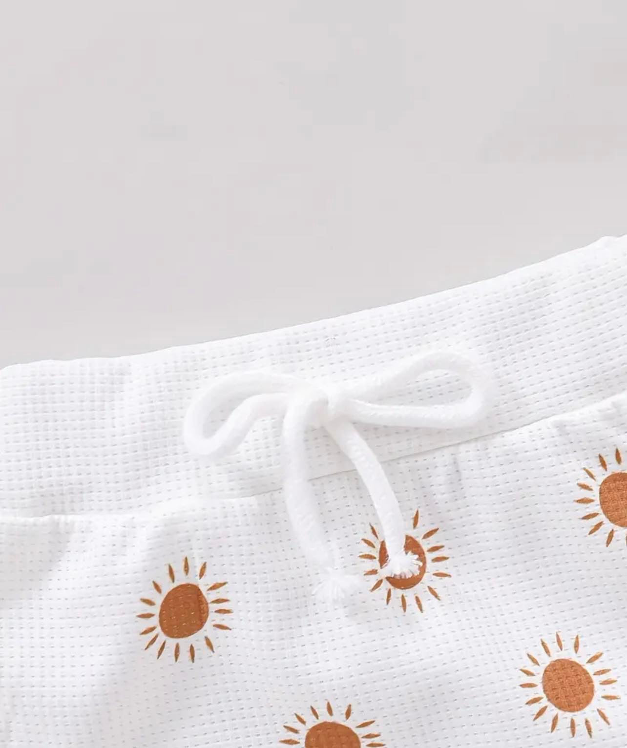 Hide and Chic's baby girls' sun graphic print onesie and shorts set, designed for comfort and style in sunny weather.