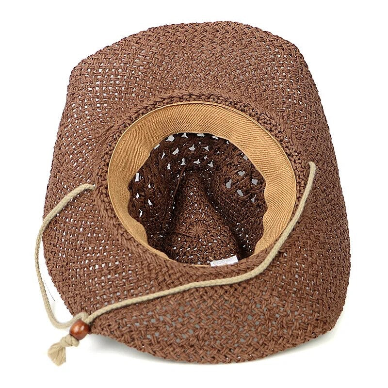 Tumbleweed Rancher Western cowboy hat displayed on a wooden table, highlighting its wide brim and stylish straw construction.