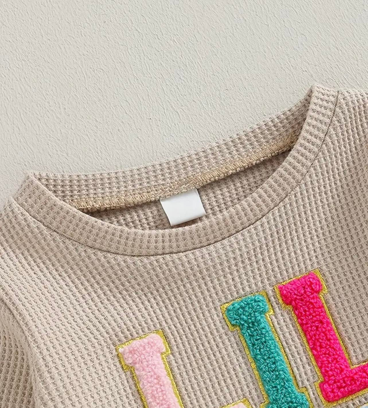 Waffle knit 'Lil Sis' Tracksuit with embroidered lettering and matching joggers, perfect for baby and toddler girls' playful and cozy days.