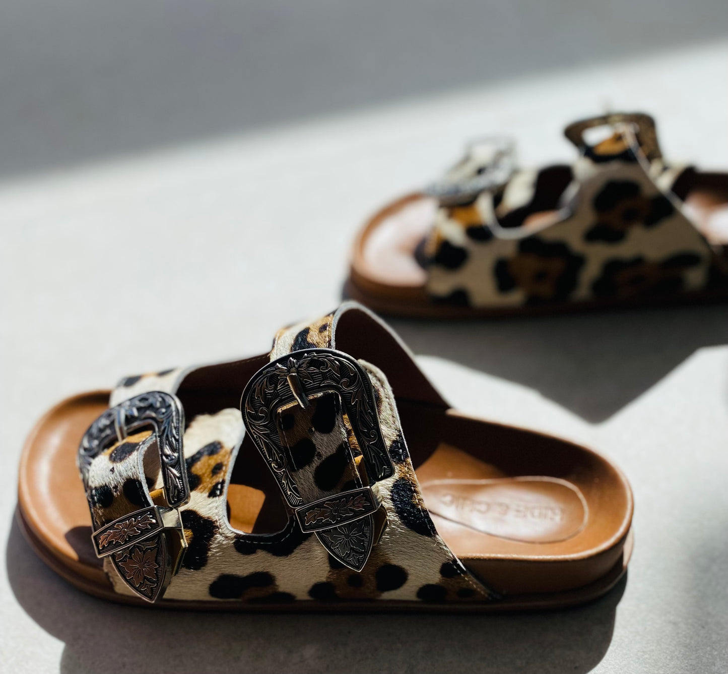 Close-up of Western Slide Sandals showcasing the detailed silver studs and cowboy-style buckles, ideal for a chic western-inspired look.