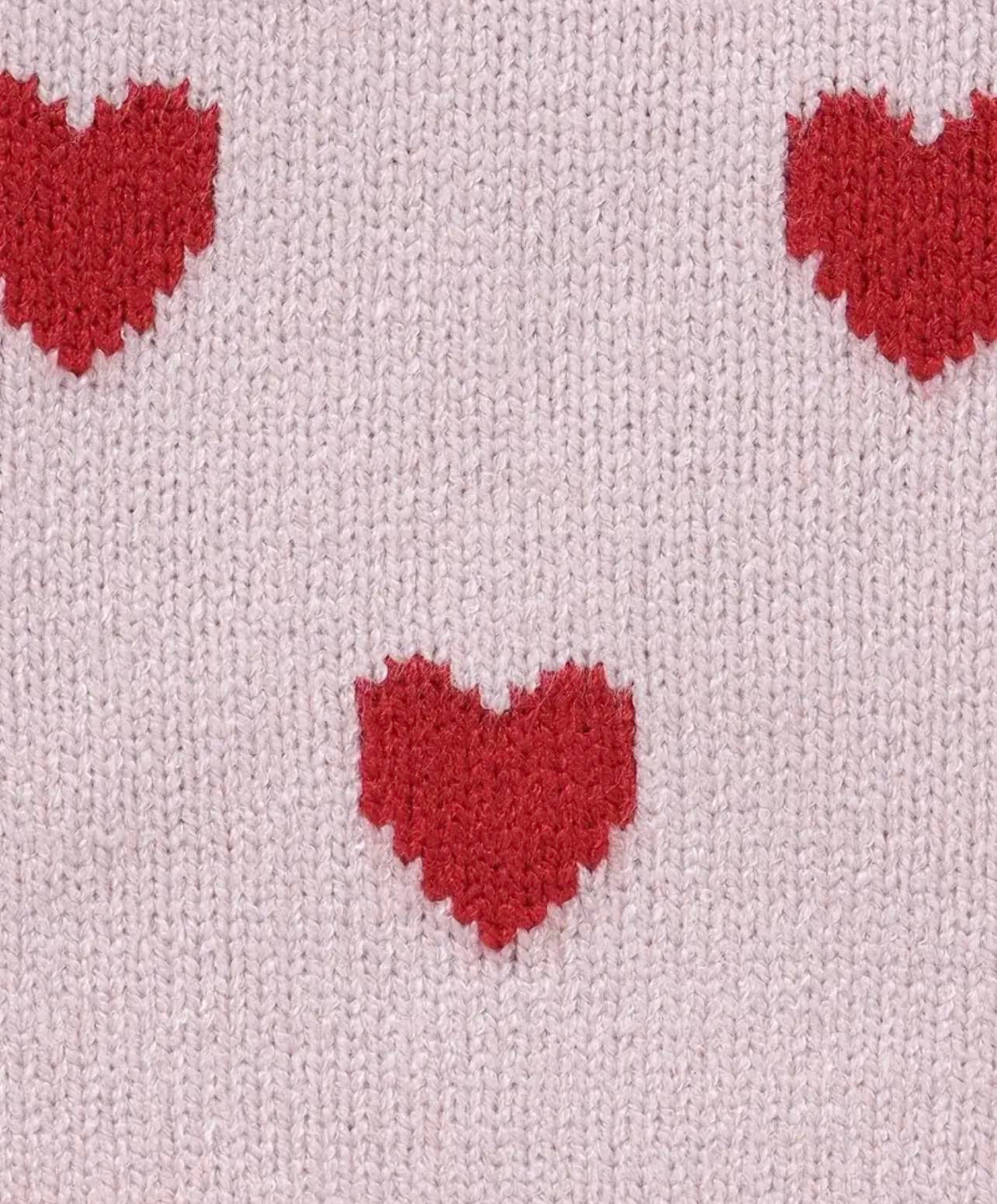 Close-up of heart print ruffle knit onesie with square neck and sleeveless design.